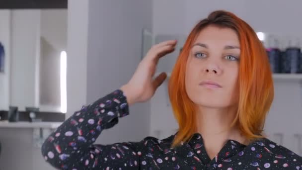 Hezká mladá žena s barvou oranžovou vlasů v kadeřnictví — Stock video