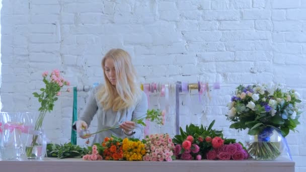 Professionell florist arbetar med blommor på studio — Stockvideo