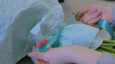 Profesyonel çiçekçi çiçek dükkanında şerit güzel buket çevresinde tamamladı