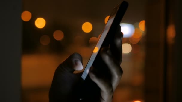 Vrouw die 's nachts verticale zwarte smartphone gebruikt — Stockvideo