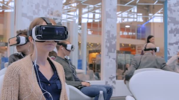 Teknoloji fuarında sanal gerçeklik kulaklığı kullanan bir grup insan — Stok video