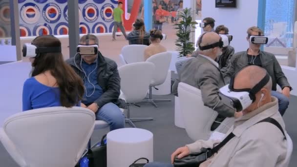 テクノロジーショーで仮想現実ヘッドセットを使用している人々のグループ — ストック動画