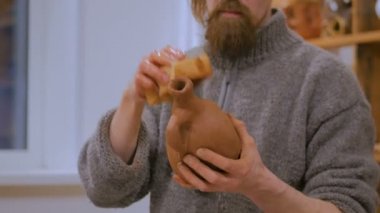 Çömlek atölyesinde özel bir aletle profesyonel çömlekçi şekillendirme kupası