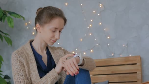 Жінка використовує розумний годинник вдома — стокове відео