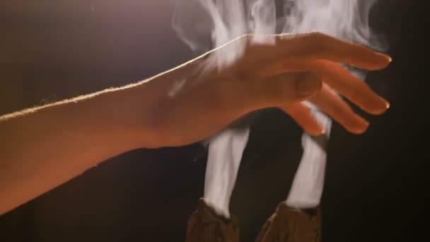 Smoke from incense rises through fingers — Stock Video