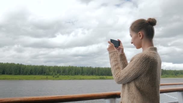 Жінка фотографує пейзаж зі смартфоном на палубі круїзного корабля — стокове відео