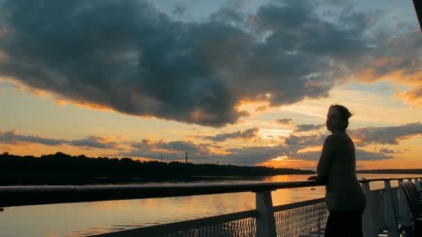 Женщина, любующаяся закатом с палубы круизного судна — стоковое видео