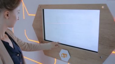 Modern teknoloji sergisinde etkileşimli dokunmatik ekran kullanan kadın
