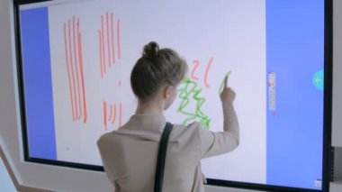 Çizim teknoloji sergisi için etkileşimli dokunmatik ekran kullanan kadın