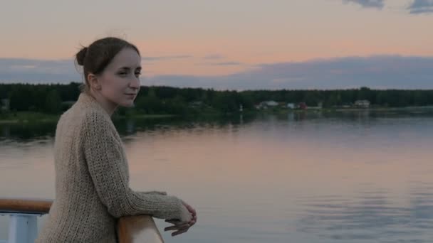 Женщина любуется пейзажем с палубы круизного судна после заката — стоковое видео