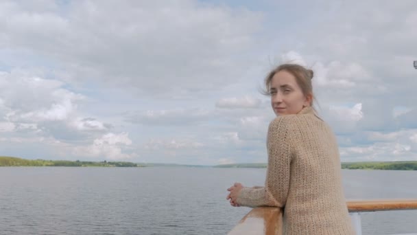 Jonge vrouw staande op het dek van het cruiseschip en kijken naar de rivier en landschap — Stockvideo