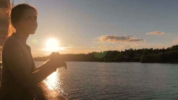 Kvinde beundrer solnedgang fra dæk af krydstogtskib – Stock-video
