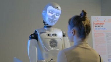 Kadın, teknoloji sergisi ile konuşurken ekran yüzü ile komik insansı robot
