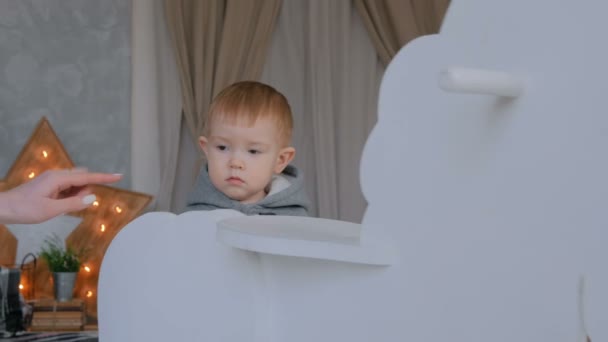 Niño jugando con el caballo mecedora de madera — Vídeo de stock