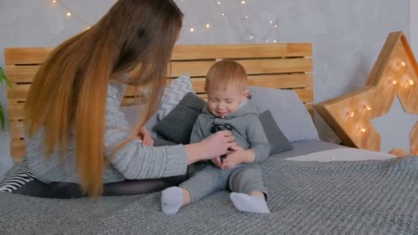 Glückliche junge Mutter und ihr kleiner Sohn spielen zusammen — Stockvideo