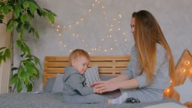 Mutlu genç anne ve küçük oğlu birlikte oynuyorlar.