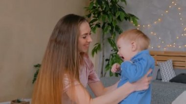 Mutlu genç anne ve küçük oğlu birlikte oynuyorlar.