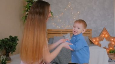 Mutlu genç anne ve küçük oğlu birlikte oynuyorlar.