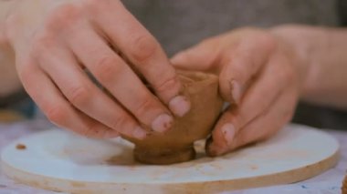 Çömlek atölyesinde kupa yapan profesyonel erkek çömlekçi.