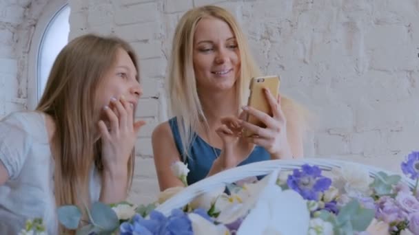 Femme prenant des photos de grand panier floral avec des fleurs avec smartphone . — Video