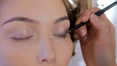 Profesyonel makyöz göz farı kullanıyor.
