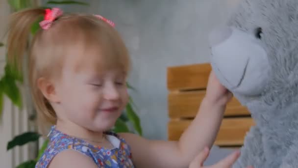 Porträt eines lustigen kleinen Mädchens mit Bärenpuppe zu Hause — Stockvideo