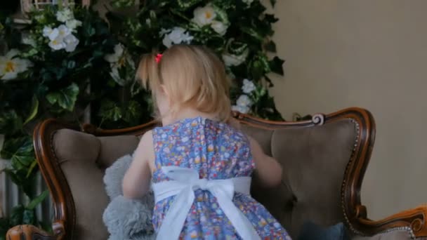 Портрет забавной маленькой девочки с медвежьей куклой дома — стоковое видео