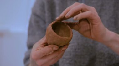 Çömlek atölyesinde kupa yapan profesyonel erkek çömlekçi.