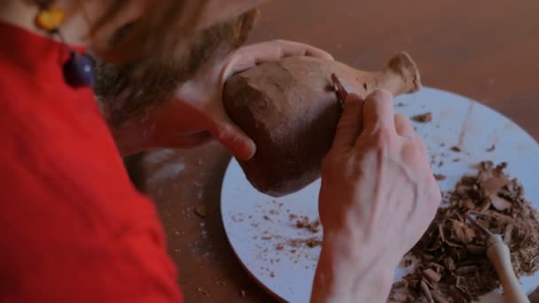 Professional potter shaping dry clay jar with special tool in pottery workshop — Stock Video