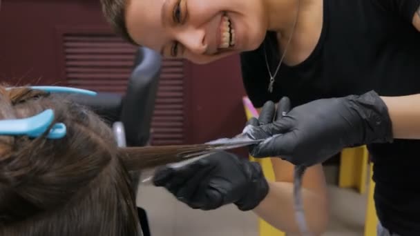 Professionele kapper kleuren haar voor vrouw client in studio — Stockvideo