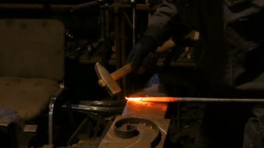 Demirci metalle çalışıyor.