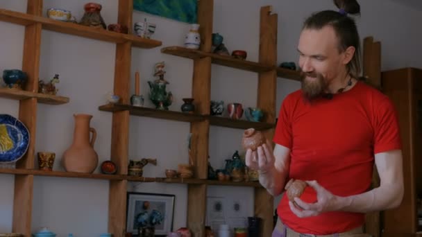 Професійний чоловічий гончар, що вивчає чашки в керамічній майстерні — стокове відео