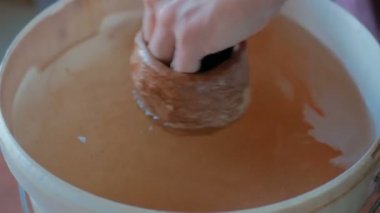 Potter, kilden bardağı suya batırıyor.