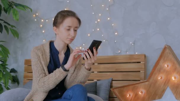 Vrouw met verticale zwarte smartphone thuis — Stockvideo
