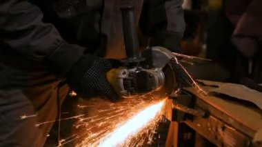 Demirci el testeresiyle metal kesiyor.