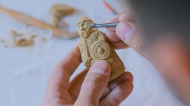 Potter, masa oyunu için kil figürü yapıyor