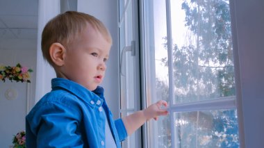 Pencereden bakan düşünceli küçük çocuk