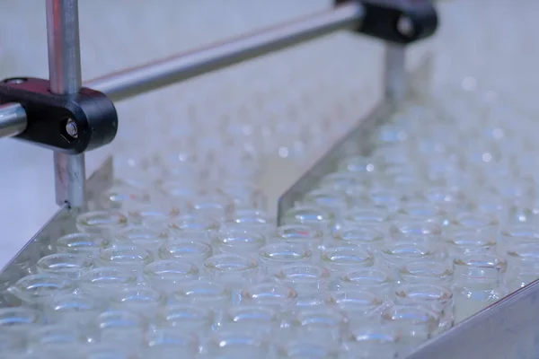 Pharmaceutical technology concept - conveyor belt with empty glass bottles
