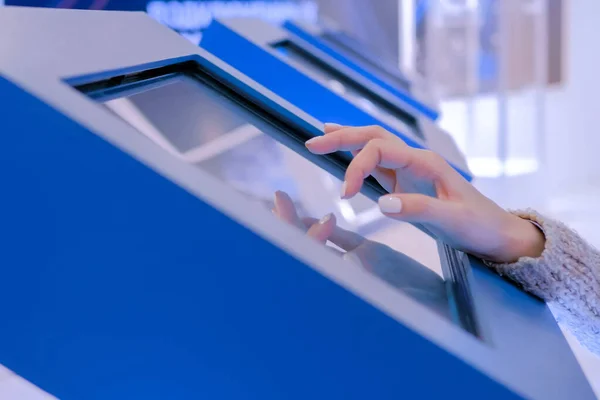 Teknoloji sergisinde etkileşimli dokunmatik ekran kullanan kadın