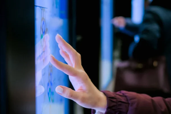 Woman using interactive touchscreen display with city map