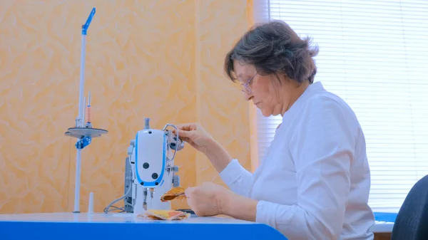 Женщина дизайнер швейная одежда с швейной машинкой в ателье — стоковое фото