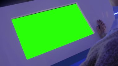 Yeşil ekran konsepti - boş etkileşimli yeşil ekran kioskuna bakan kadın