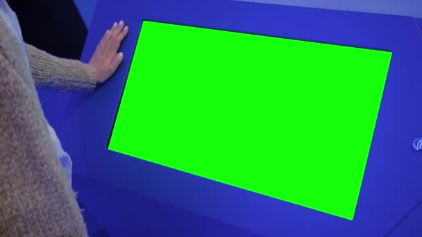 Frau betrachtet leeren grünen Ausstellungskiosk - Green-Screen-Konzept — Stockvideo