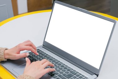 Gri dizüstü bilgisayar klavyesinde beyaz beyaz ekran ile yazan kadın öğrenci