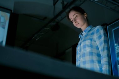 Genç bir kadın elektronik büfeye bakıyor.