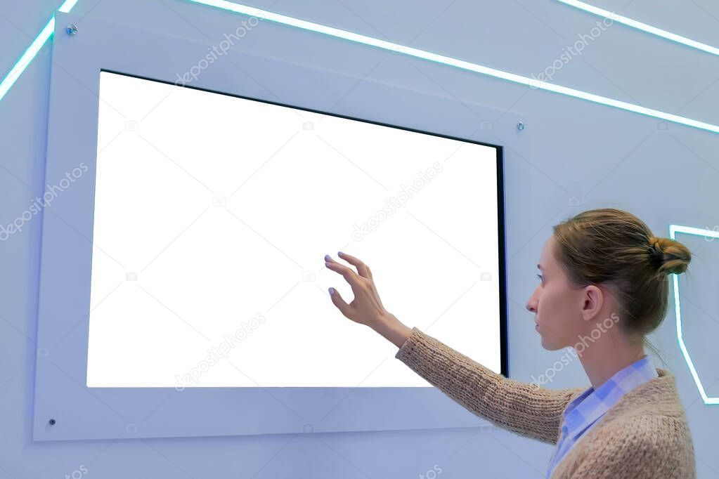 Woman touching blank white display wall at exhibition - white screen concept
