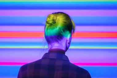 Çok renkli ışık aydınlatmaile modern sergiye bakan kadın