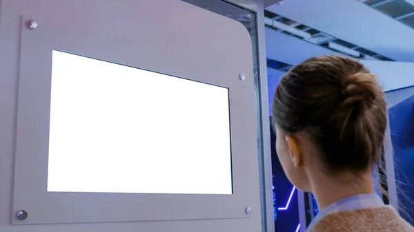 White screen concept - woman looking at blank white display wall at exhibition