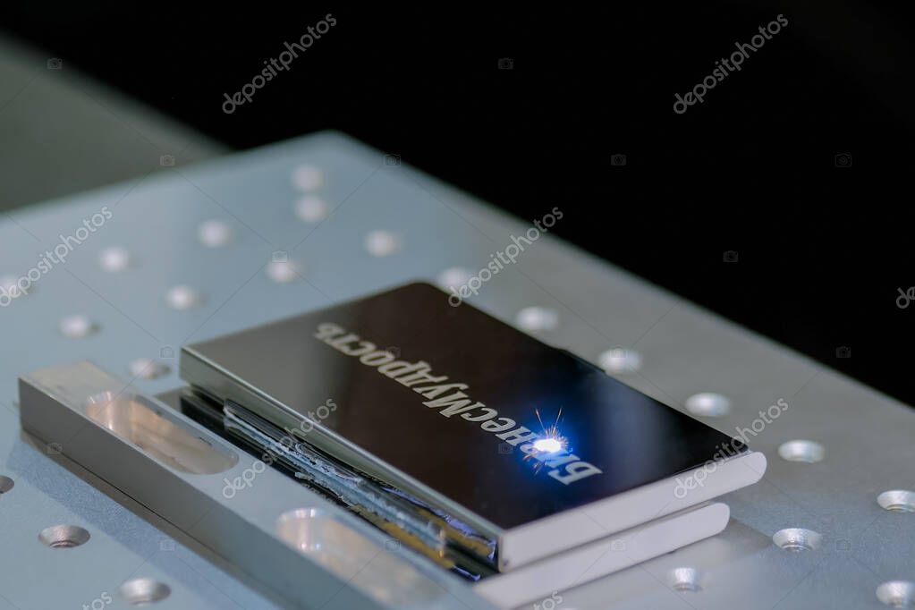 MOSCOW, RUSSIA - JUNE 30, 2019: Smart Expo. Fiber laser engraving machine marking metal business card at exhibition, trade show. Design, personalization, automated technology equipment concept