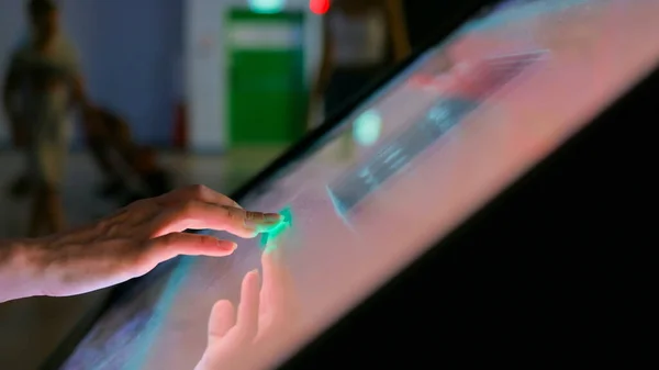 Woman using interactive touchscreen display at modern museum